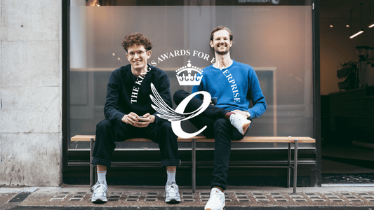 Two co-founders of Redemption Roasters, the coffee shop who train up prison leavers with barista skills to reduce reoffending, with the Kings Award for Enterprise logo, which they have been awarded
